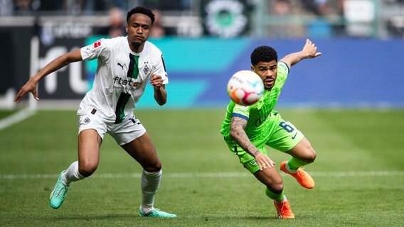 Wolfsburgs Paulo Otavio (r.) und Gladbachs Nathan Ngoumou kämpfen um den Ball. © picture alliance/dpa | Marius Becker 