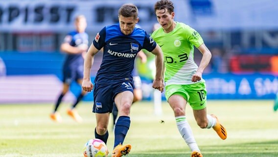 Wolfsburgs Jakub Kaminski (r.) und Berlins Jonjoe Kenny kämpfen um den Ball. © IMAGO / Eibner 