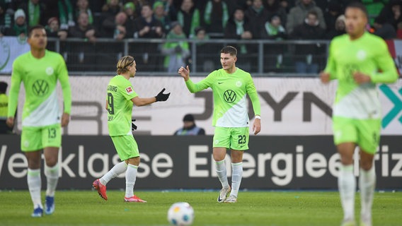 Wolfsburgs Jonas Wind (r.) und Lovro Majer bejubeln einen Treffer. © picture alliance/dpa | Swen Pförtner 