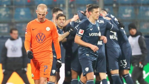 Wolfsburgs Vaclav Cerny ist enttäuscht, während im Hintergrund Bochumer Spieler einen Treffer bejubeln. © IMAGO / regios24 