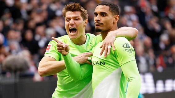 Wolfsburgs Maxence Lacroix (r.) und Kevin Behrens bejubeln einen Treffer. © IMAGO / HMB-Media 