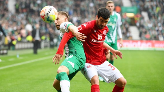 Bremens Mitchel Weiser (l.) und der Mainzer Aaron Martin kämpfen um den Ball. © IMAGO / Team 2 