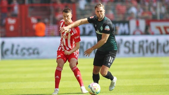 Bremens Niclas Füllkrug (r.) und Berlins Janik Haberer kämpfen um den Ball. © IMAGO / Jan Huebner 