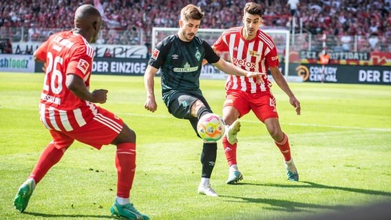 Bremens Romano Schmid (M.) kämpft gegen Berlins Jerome Roussillon (l.) und Diogo Leite um den Ball. © IMAGO / Beautiful Sports 