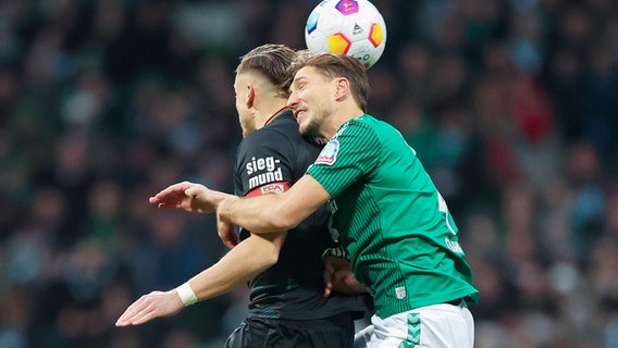 Bremens Niklas Stark (r.) und Augsburgs Ermedin Demirovic kämpfen um den Ball. © IMAGO / eu-images 