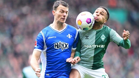 Bremens Felix Agu (r.) und Darmstadts Christoph Zimmerman kämpfen um den Ball. © Witters/LeonieHorky 
