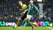 Bremens Justin Njinmah (r.) und Dortmunds Nico Schlotterbeck kämpfen um den Ball. © IMAGO / MIS 