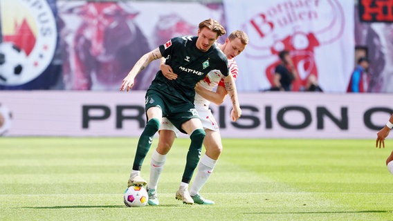 Bremens Nick Woltemade (m.) im Zweikampf mit Leipzigs Lukas Klostermann © Imago Images 