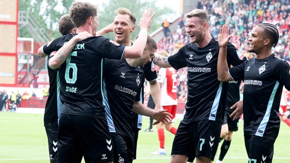 Bremen-Spieler um Torschütze Jens Stage (l.) bejubeln einen Treffer. © IMAGO / Nordphoto 