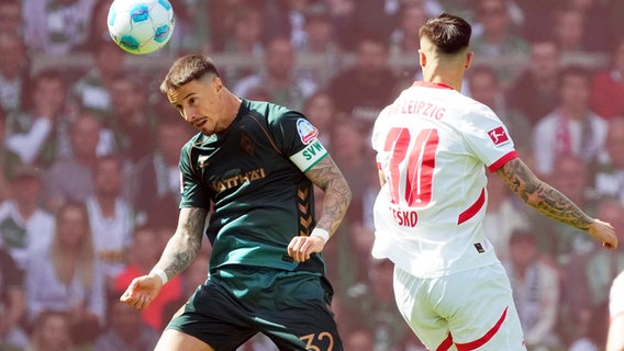 Bremens Marco Friedl (l.) und Leipzigs Benjamin Sesko kämpfen um den Ball. © Witters/FrankPeters 