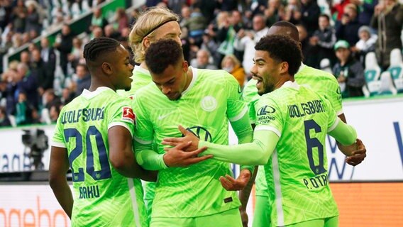 Wolfsburgs Torschütze Lukas Nmecha (M.) und seine Mitspieler bejubeln einen Treffer. © IMAGO / Joachim Sielski 
