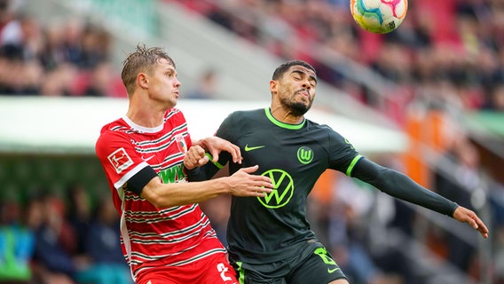 Wolfsburgs Paulo Otavio (r.) und Augsburgs Robert Gumny kämpfen um den Ball. © IMAGO / Passion2Press 