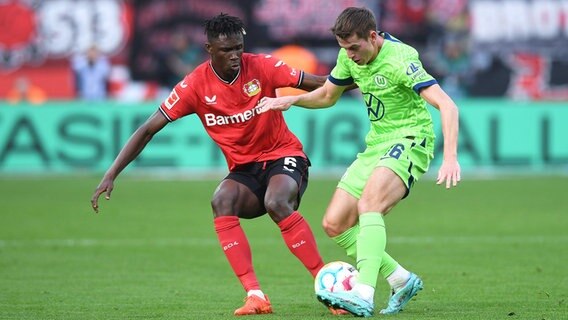 Wolfsburg Jakub Kaminski (r.) und Leverkusens Odilon Kossounou kämpfen um den Ball. © IMAGO / Revierfoto 