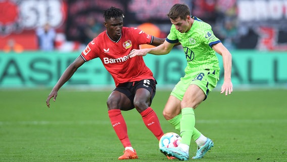 Wolfsburg Micky van de Ven (r.) und Leverkusens Moussa Diaby kämpfen um den Ball. © picture alliance/dpa | Federico Gambarini 