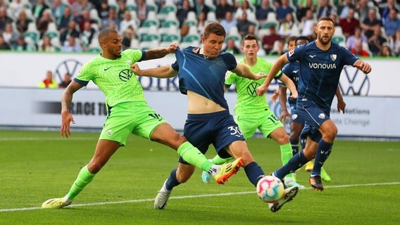 Wolfsburgs Lukas Nmecha (l.) und Bochums Dominique Heintz kämpfen um den Ball. © IMAGO / regios24 