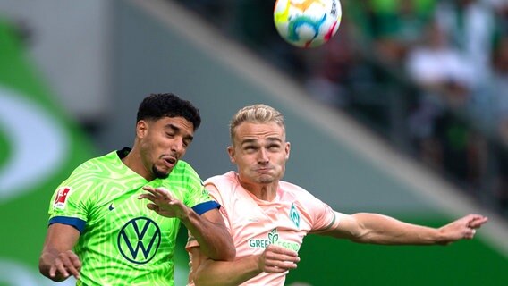 Wolfsburgs Omar Marmoush (l.) und Bremens Amos Pieper kämpfen um den Ball. © Swen Pförtner/dpa 