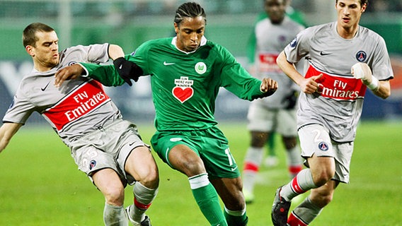 Wolfsburgs Stürmer Caiuby setzt sich gegen zwei Pariser Spieler durch. © dpa 