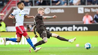 Simon Makienok (r.) vom FC St. Pauli erzielt im Zweitliga-Stadtderby am 13. August 2021 gegen den Hamburger SV das 3:1 für den Kiezclub. Links: Jan Gyamerah.