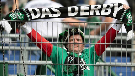 Ein Hannover-Fan hält einen Schal mit der Aufschrift "Das Derby" in die Höhe. © picture alliance / dpa Foto: Swen Pförtner
