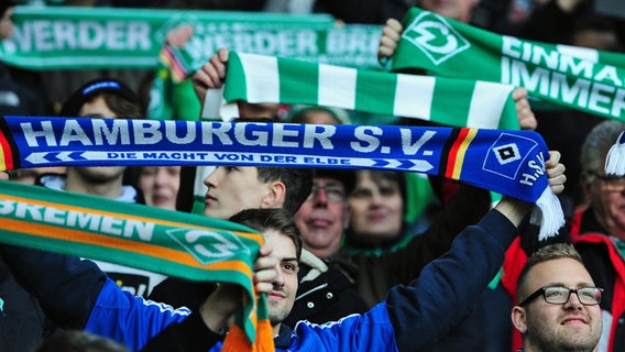 Fans des Hamburger SV und von Werder Bremen schwenken Schals. © picture alliance / dpa 