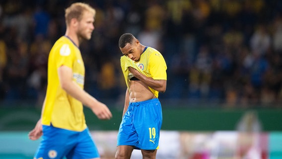 Braunschweigs Anton Donkor (r.) ist enttäuscht, während Sebastian Griesbeck nach einem Platzverweis den Rasen verlässt. © picture alliance/dpa | Swen Pförtner 