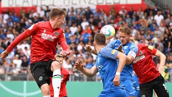 Der Mainzer Tim Müller (2.v.r.) und Hannovers Maximilian Beier (l.) kämpfen um den Ball. © picture alliance/dpa | Torsten Silz 
