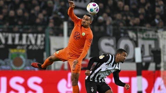 Wolfsburgs Maxence Lacroix (l.) und Gladbachs Alassane Plea kämpfen um den Ball. © IMAGO / Eibner 