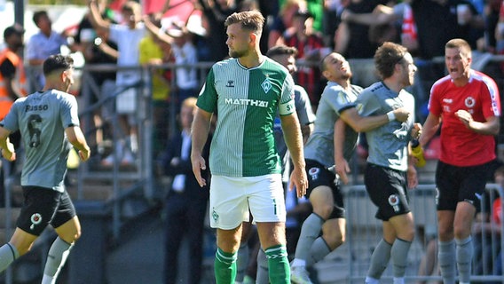 Bremen Niclas Füllkrug ist enttäuscht, während im Hintergrund Kölns Spieler einen Treffer bejubeln. © IMAGO / Treese 