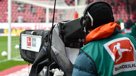 Ein Kamermann steht am Rande eines Spielfeldes, um ein Bundesliga-Spiel zu filmen. © IMAGO / Jan Huebner 