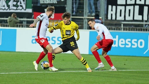 Dortmunds Julian Hettwer (m.) im Zweikampf mit Lübecks Marvin Thiel (l.). © Imago Images 