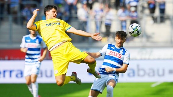 Braunschweigs Jannis Nikolaou (l.) und Duisburgs Alaa Bakir kämpfen um den Ball. © IMAGO / Team 2 