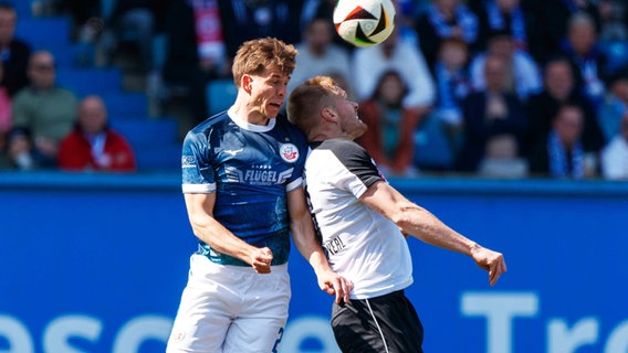Rostocks Alexander Rossipal (l.) und Verls Lars Lokotsch kämpfen um den Ball. © IMAGO / Andy Bünning 