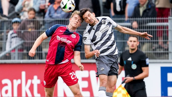 Rostocks Felix Ruschke (l.) und Sandhausens Sebastian Stolze kämpfen um den Ball. © IMAGO / foto2press 