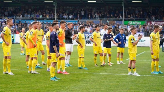 Braunschweigs Spieler sind enttäuscht und verabschieden sich von den mitgereisten Fans. © IMAGO / Werner Scholz 