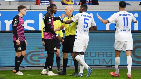 Osnabrücks Aaron Opuku (2.v.l.) beschwert sich bei Schiedsrichter Nicolas Winter (M.), dass er von Fans rassistisch beleidigt wurde. © IMAGO / Team 2 