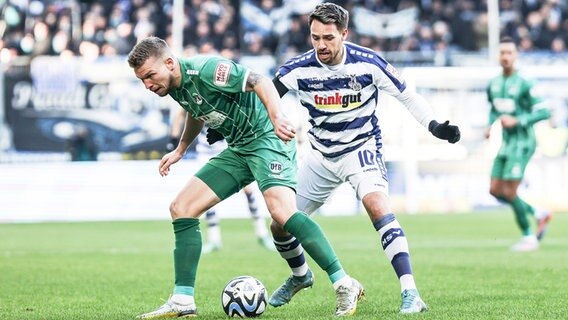 Lübecks Janek Sternberg (l.) und Duisburgs Thomas Pledl kämpfen um den Ball. © IMAGO / Nico Herbertz 