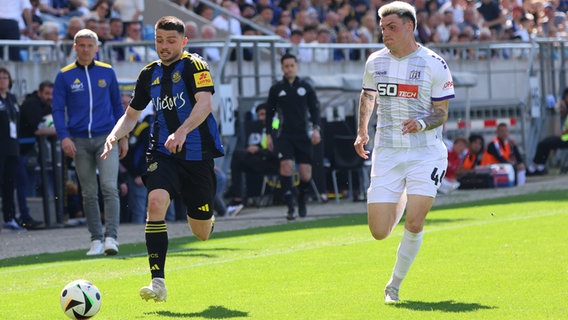 Osnabrücks Niklas Kölle (r.) und Saarbrückens Maurice Multhaup kämpfen um den Ball. © picture alliance / Fußball-News Saarland | Sebastian Bach 