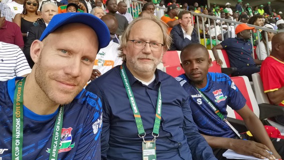 Robert Echelmeyer (v.l.), Gambia-Chefcoach Tom Saintfiet und Teamscout Lamin Sanneh beim Afrika-Cup 2024 Robert Echelmeyer (v.l.), Gambia-Chefcoach Tom Saintfiet und Teamscout Lamin Sanneh beim Afrika-Cup 2024 © NDR