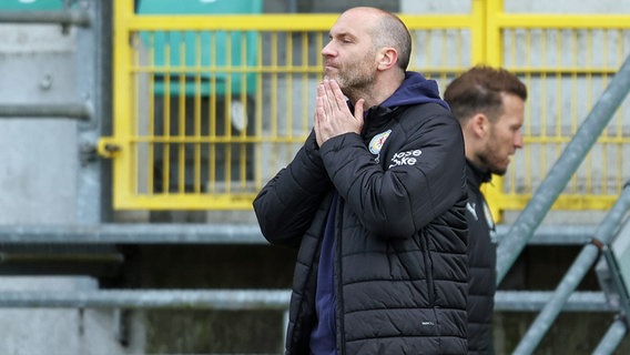 Eintracht Braunschweigs Trainer Daniel Scherning hält die Hände vor das Gesicht. © picture-alliance / DPA 
