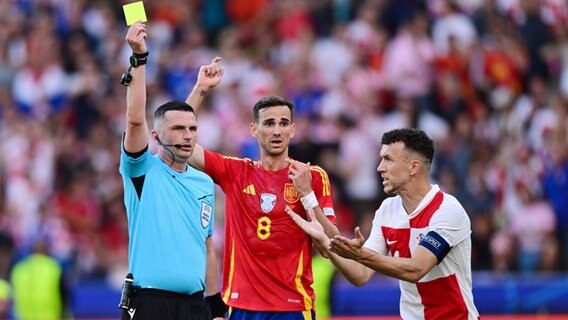 Schiedsrichter Michael Oliver (England) zeigt die Gelbe Karte, Fabian Ruiz (Spanien) und Ivan Perisic (Kroatien) sind entsetzt. © Witters 