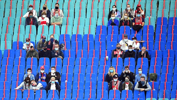 Fans mit Mundschutz in einem Fußballstadion © Witters 