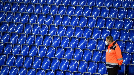 Ein Ordner mit Mund-Nasen-Schutz im Fußballstadion © IMAGO / Poolfoto 