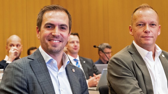 Philipp Lahm (l.), Turnierdirektor, und Markus Stenger, Geschäftsführer der EM 2024, sitzen im Rathaus im Sportausschuss der Hamburgischen Bürgerschaft. © picture alliance / dpa 