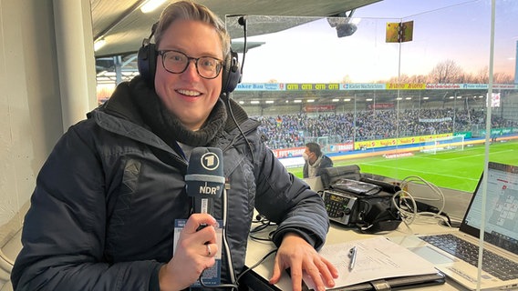 Fußballreporter Matthias Dröge in der Kabine im Stadion mit NDR Mikrophon in der Hand © Matthias Dröge 
