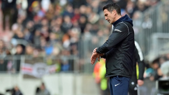 Patrick Glöckner schaut auf die Uhr. © IMAGO / osnapix 