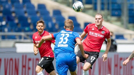 Hannovers Dominik Kaiser (l.) und Marvin Ducksch (r.) setzen Heidenheims Timo Beermann unter Druck. © imago images / Poolfoto 