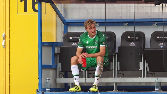 Hannover-96-Profi Timo Hübers sitzt auf einer Auswechselbank © Friso Gentsch/dpa 