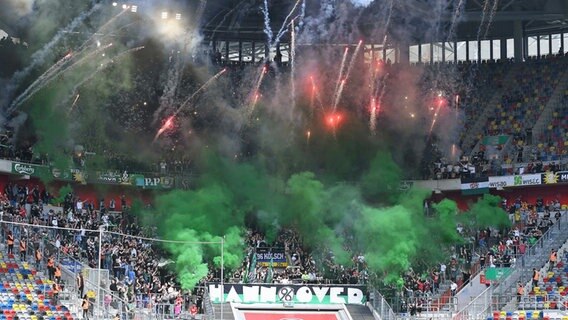 Fans von Hannover 96 zünden Pryotechnik im Düsseldorfer Stadion. © IMAGO / revierfoto 
