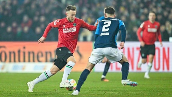 Hannovers Cedric Teuchert (l.) versucht, an Kaiserslauterns Boris Tomiak vorbeizukommen. © IMAGO / Nordphoto 