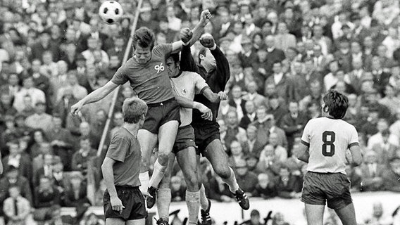 Jupp Heynckes (l.) von Hannover 96 im Luftzweikampf gegen Michael Polywka und Torwart Horst Wolter (beide Braunschweig) am 23.08.1969. © Fritz Rust Foto: Fritz Rust